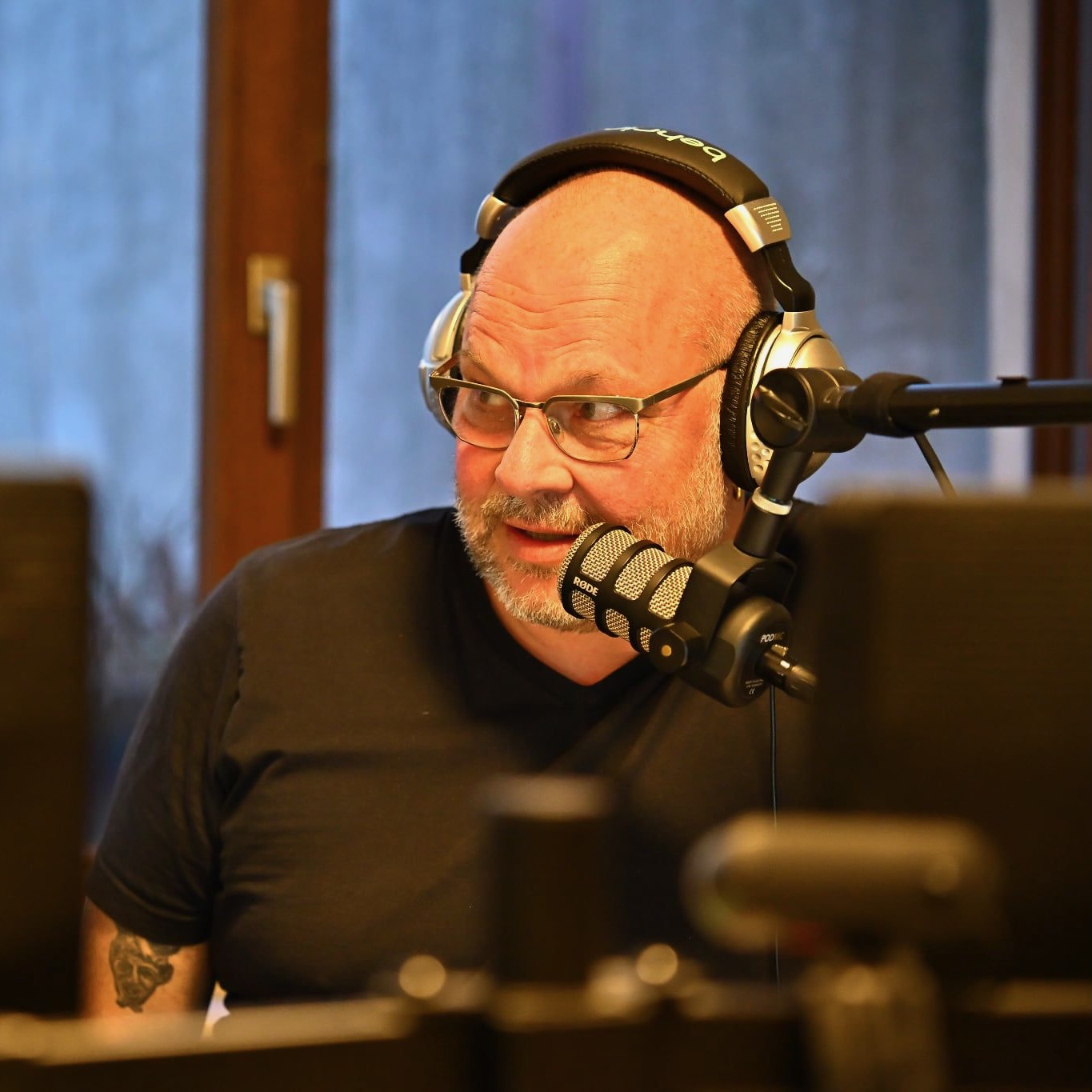 Ralf Neuhäuser konzentriert im Gespräch an einem Studiomikrofon